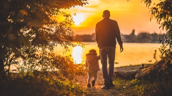 Father and Son Walking by the Lake at Sunset Christian Stock Image